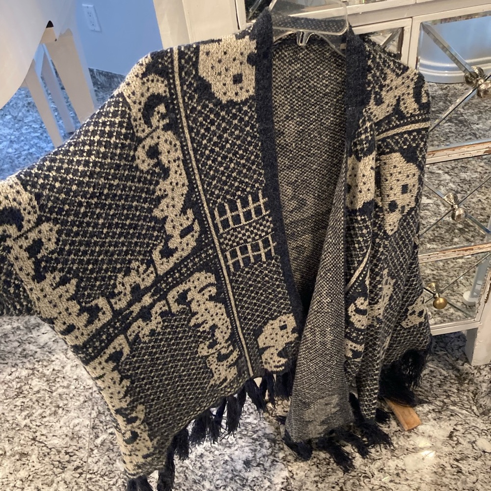 En creme soft and luxurious bohemian pattern pancho with tassels.